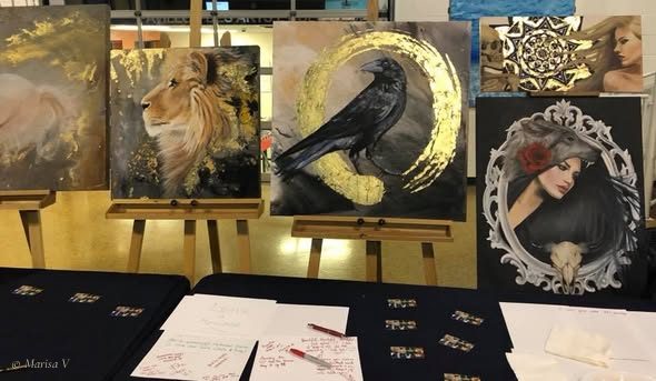 Ses toiles sur chevalets au Tour d’Italie, en 2018 : un lion, un corbeau dans un cercle d’or et un portrait de femme dans un cadre ovale ouvragé.