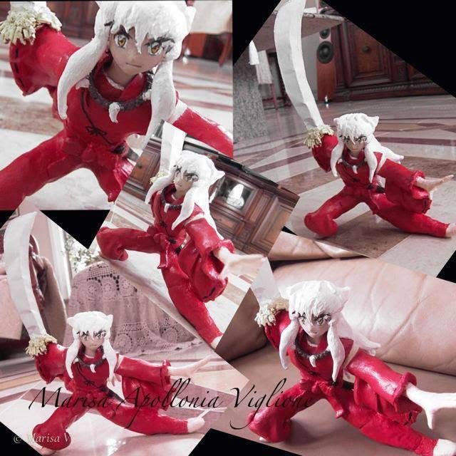Painted clay figurine of Inuyasha in a fighting stance, with white hair, a red kimono and a raised sword.