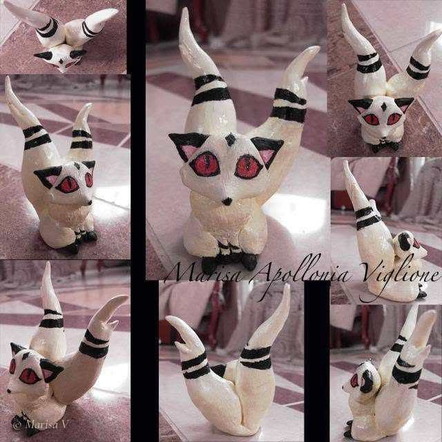 Painted clay figurine of a cream cat with red eyes and two black-striped tails, seen from several angles.