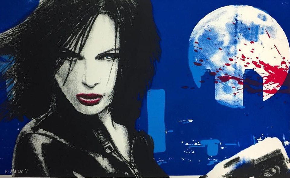 Blue silkscreen of a dark-haired woman with red lips, before a red-spattered full moon and a city skyline.